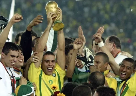 رونالدو يرفع كأس العالم الفائز به مع البرازيل عام 2002 (Getty)